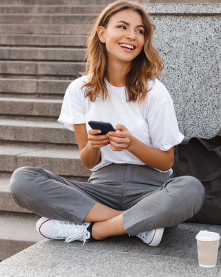 smiling teenager holding her phone