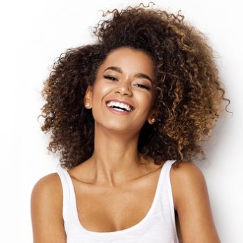 young woman smiling against white background